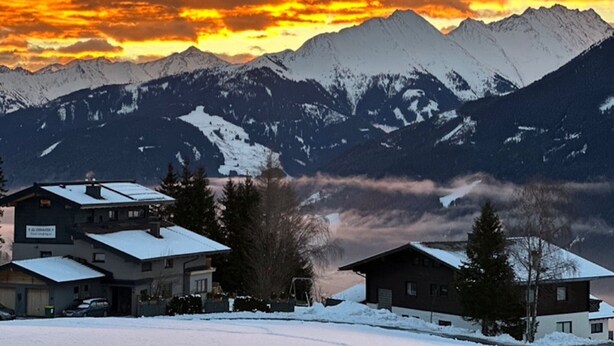 A mountain landscape with snow-covered houses and a sunset. - Fantastic Apartment in the Kitzbuhel Alps (Mittersill)