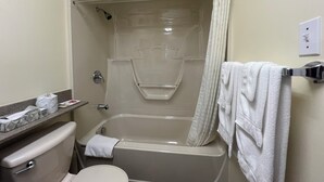 Ein Badezimmer mit Badewanne, Toilette und Handtuchhalter.