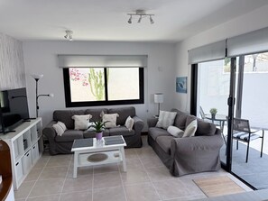 A modern living room with a sofa, coffee table, and a TV.