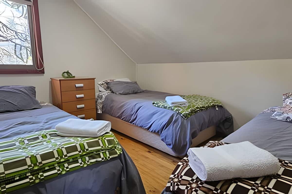Ein Schlafzimmer mit zwei Betten, einem Schminktisch und einem Fenster.