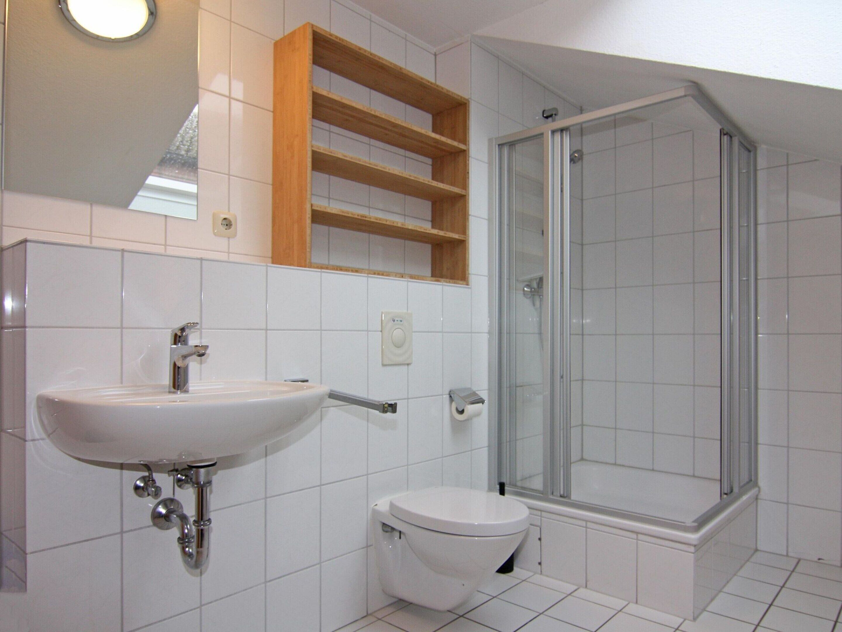 Un bagno con lavandino, water e doccia vetrata.