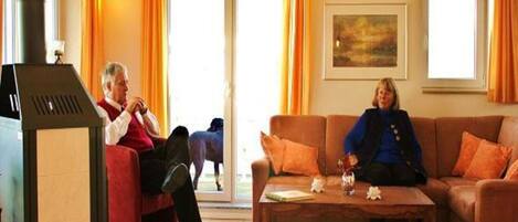 Una sala de estar con chimenea, un sofá, una mesa de centro y un cuadro en la pared.