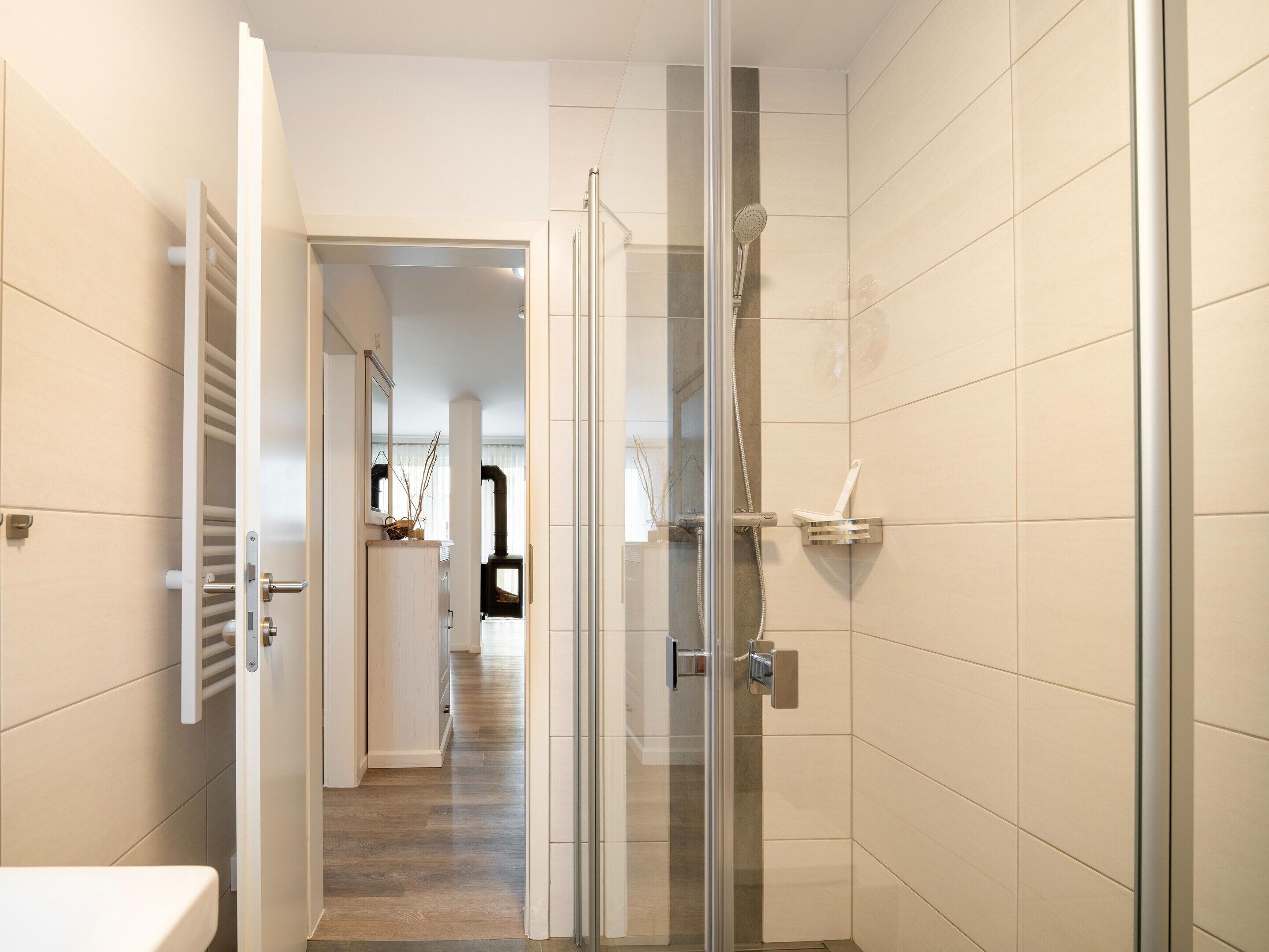Une salle de bain moderne avec une douche à parois de verre, des toilettes et un lavabo.