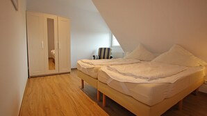 A bedroom with a bed, a wardrobe, and a window. - Ferienwohnung auf Usedom im Lepels Hof bis zu 5 P (Luetow)