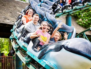 A roller coaster with passengers seated in the cars.
