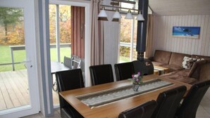A dining area with a wooden table, black chairs, and a view of the outdoors. - Ferienhaus im Skandinavischen Stil (Mirow)