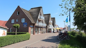 A street with traditional brick buildings, a clear sky, and bicycles parked along the sidewalk. - Seepark Burhave, Burhave (Butjadingen)