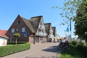 En gata med traditionella byggnader i tegel, en klar himmel och cyklar som står parkerade längs trottoaren.