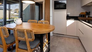 A modern kitchen with white cabinets, a built-in microwave, and a black stove. - Waterfront Stay w/ Pets (Delfstrahuizen)