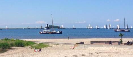 A beach with sailboats and a sandy shore.