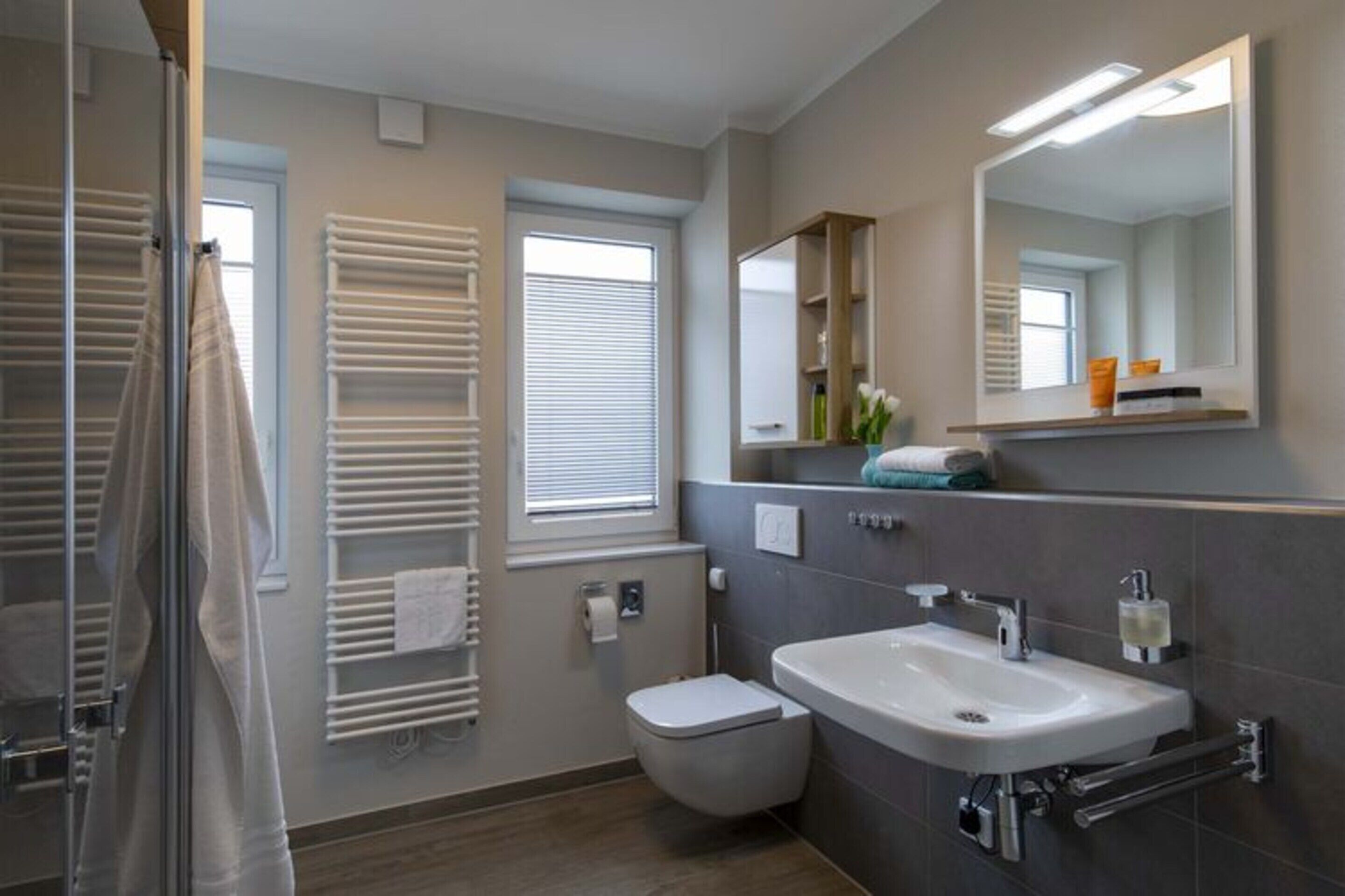 Ein modernes Badezimmer mit Dusche, Toilette und Waschbecken.