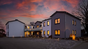 A modern two-story house with a covered entrance and a driveway. - Exclusives Appartement auf Fehmarn (Fehmarn)