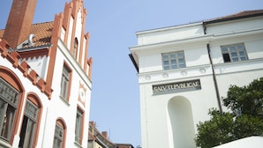 A building with a clock tower and a sign reading "SALV TLPVLICAEL". - Studio in Wismar am Alten Hafen (Wismar)