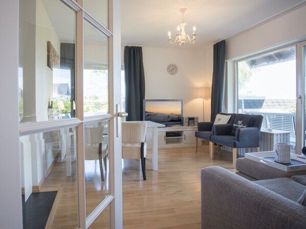 A modern living room with a TV, sofa, and dining area. - Moderne Wohnung Mitten in Winterberg mit Balkon (Winterberg)