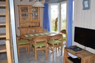 Ein Essbereich mit Holztisch, Stühlen und einem Schrank.