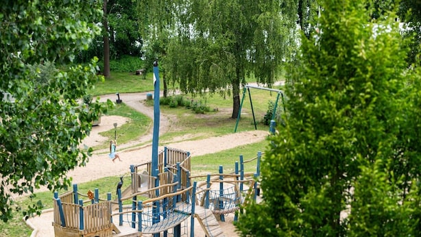 A playground with climbing structures, a slide, and a rope bridge. - Appartement mit Skandinavischem Flair (Mirow)