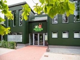 Ein Gebäude mit grüner Fassade und einem Schild mit der Aufschrift 'Frido & Skippy'.