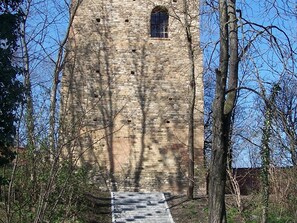 Une haute tour étroite en pierre, dotée d’une petite fenêtre et d’un escalier menant à son sommet.