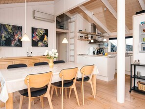 A modern kitchen with white cabinetry, wooden flooring, and pendant lighting. - 4 Star Holiday Home in Knebel (Knebel)