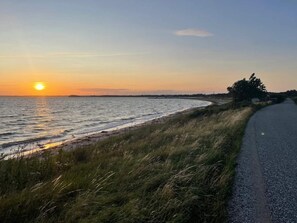 A coastal road with a view of the sea and a sunset. - 4 Star Holiday Home in Knebel (Knebel)