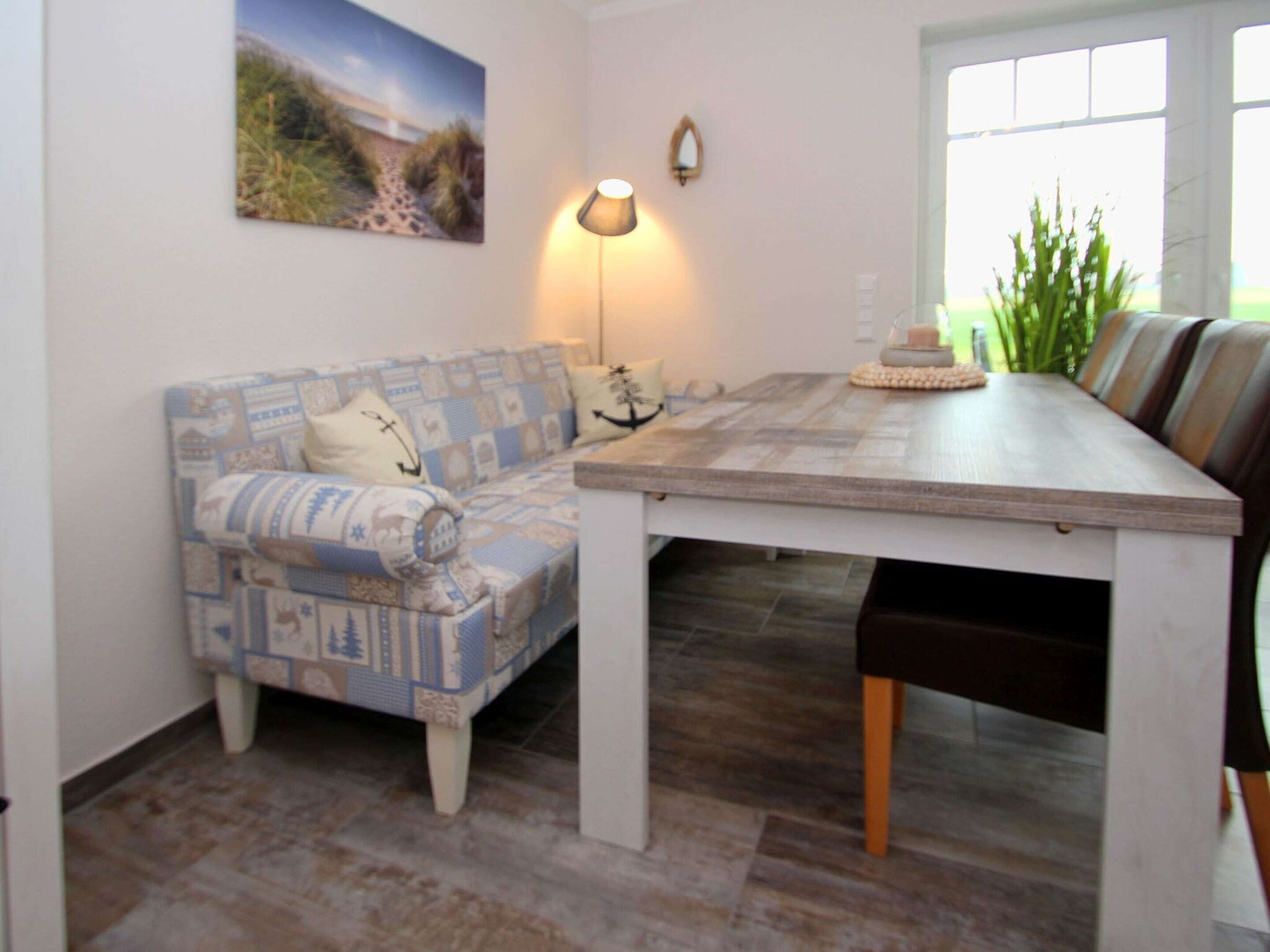 A dining area with a patterned sofa, a wooden table, and chairs.
