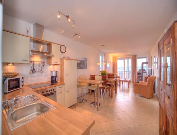Eine moderne Küche mit Essbereich, Holzmöbeln und Meerblick.