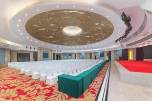 A banquet hall with a long table, red carpet, and a circular ceiling design. - Huayu International Hotel (Xiangtan)