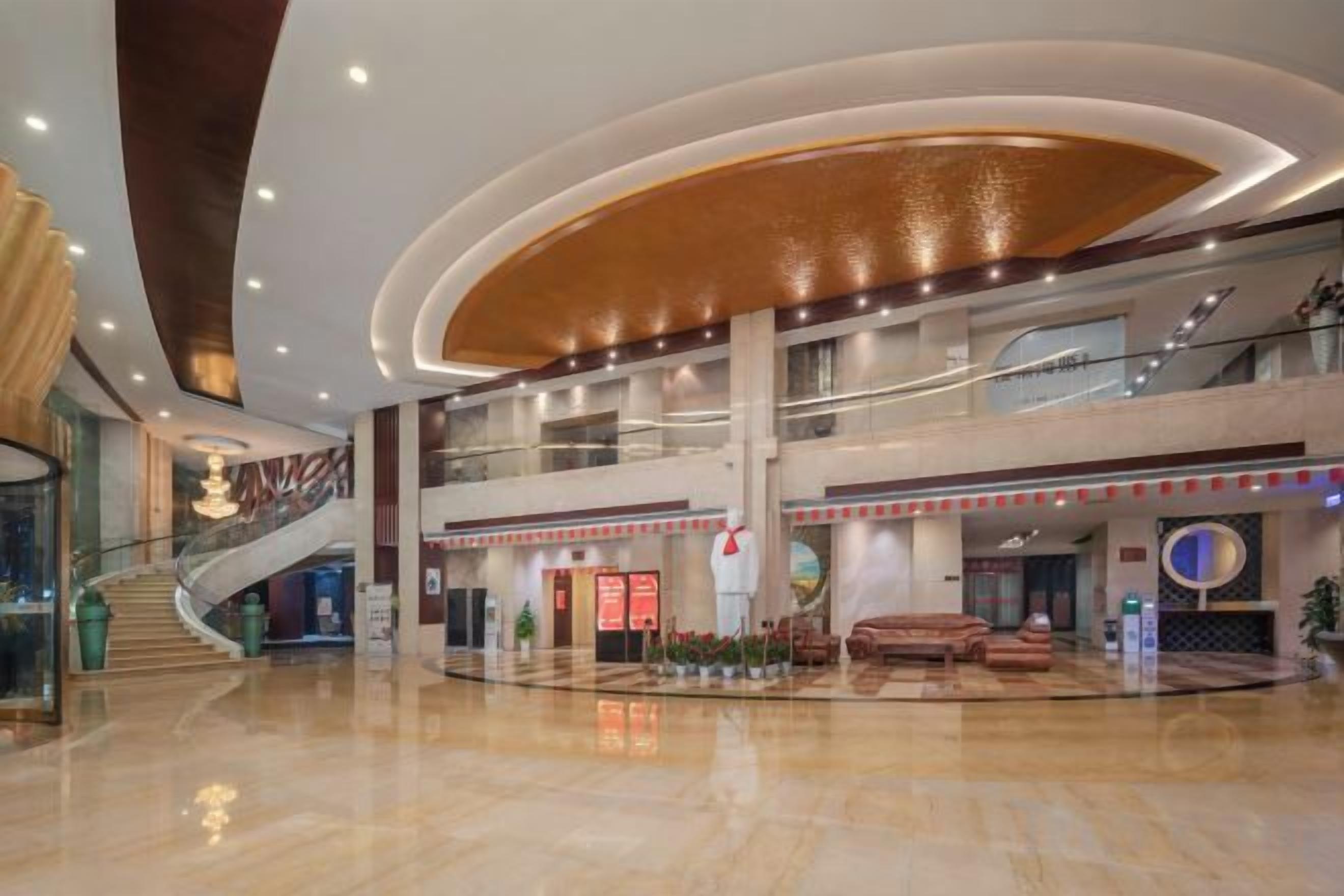 Um hall amplo com uma escadaria imponente, vários níveis e uma área de estar central.