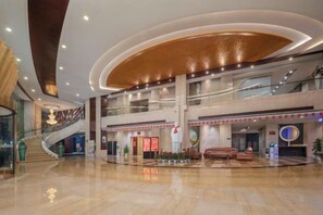 A spacious lobby with a grand staircase, multiple levels, and a central seating area. - Huayu International Hotel (Xiangtan)