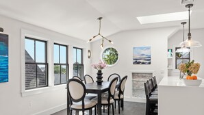 Un espace de salle à manger moderne avec une table centrale, des chaises et un lustre.