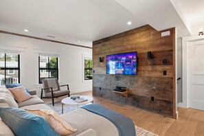 TV connectée, cheminée, livres, écrans d'ordinateur