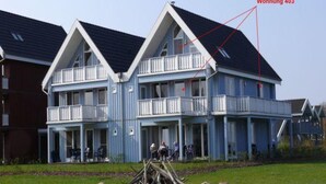 A multi-story hotel with balconies and a clear sky. - Exklusives Appartement in Rechlin (Rechlin)