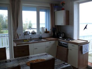 Enjoy a kitchen with a view, featuring a window, sink, stove, and countertop, perfect for cooking and taking in the surrounding scenery.