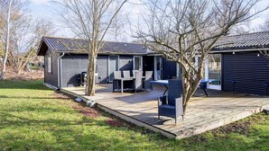 A cabin with a patio, a dining table, and chairs. - 6 Person Holiday Home in Grevinge (Grevinge)