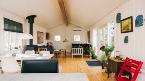 A cozy interior with a dining area, a fireplace, and a living space with a sofa and a bench.