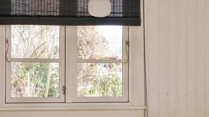 A room with two beds, a window with blinds, and a view of trees outside. - 6 Person Holiday Home in Grevinge (Grevinge)