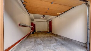 Un garaje con piso de concreto, techo de madera y paredes rojas.