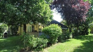 A residential property with a house, a fenced yard, and mature trees. - Ferienhaus im Ferienpark Mirow (Mirow)