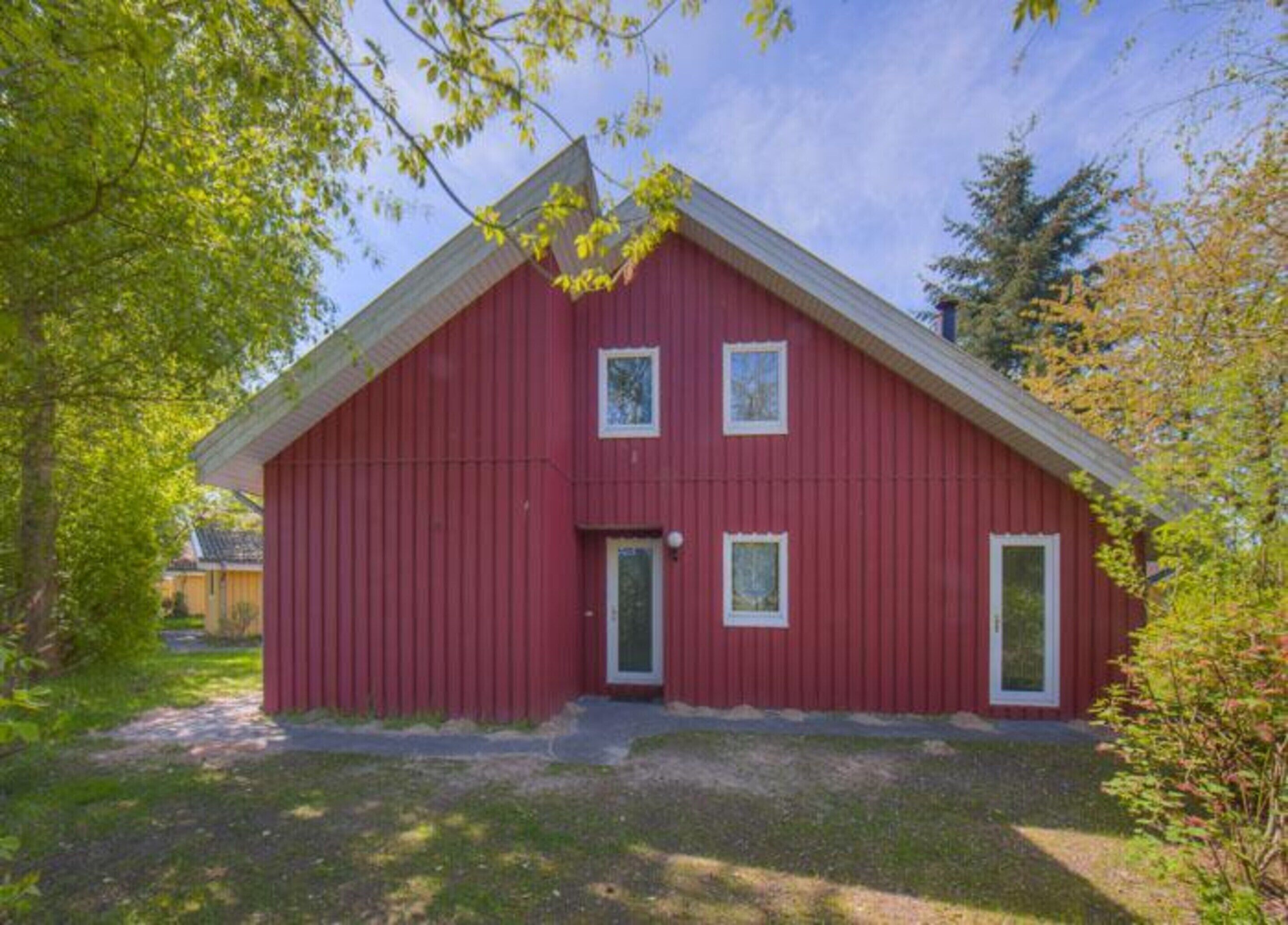 A red barn-style building with a gabled roof, a front door, and two windows.