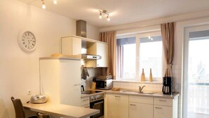 A compact kitchen with a dining area, a built-in oven, a microwave, and a sink. - Marina View Comfort Stay (Rechlin)