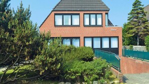 Een tweelaags gebouw van baksteen met een zadeldak, meerdere ramen en een zichtbaar naamteken.