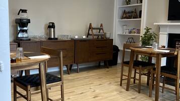 A modern kitchen with wooden furniture, a coffee maker, and a fireplace.