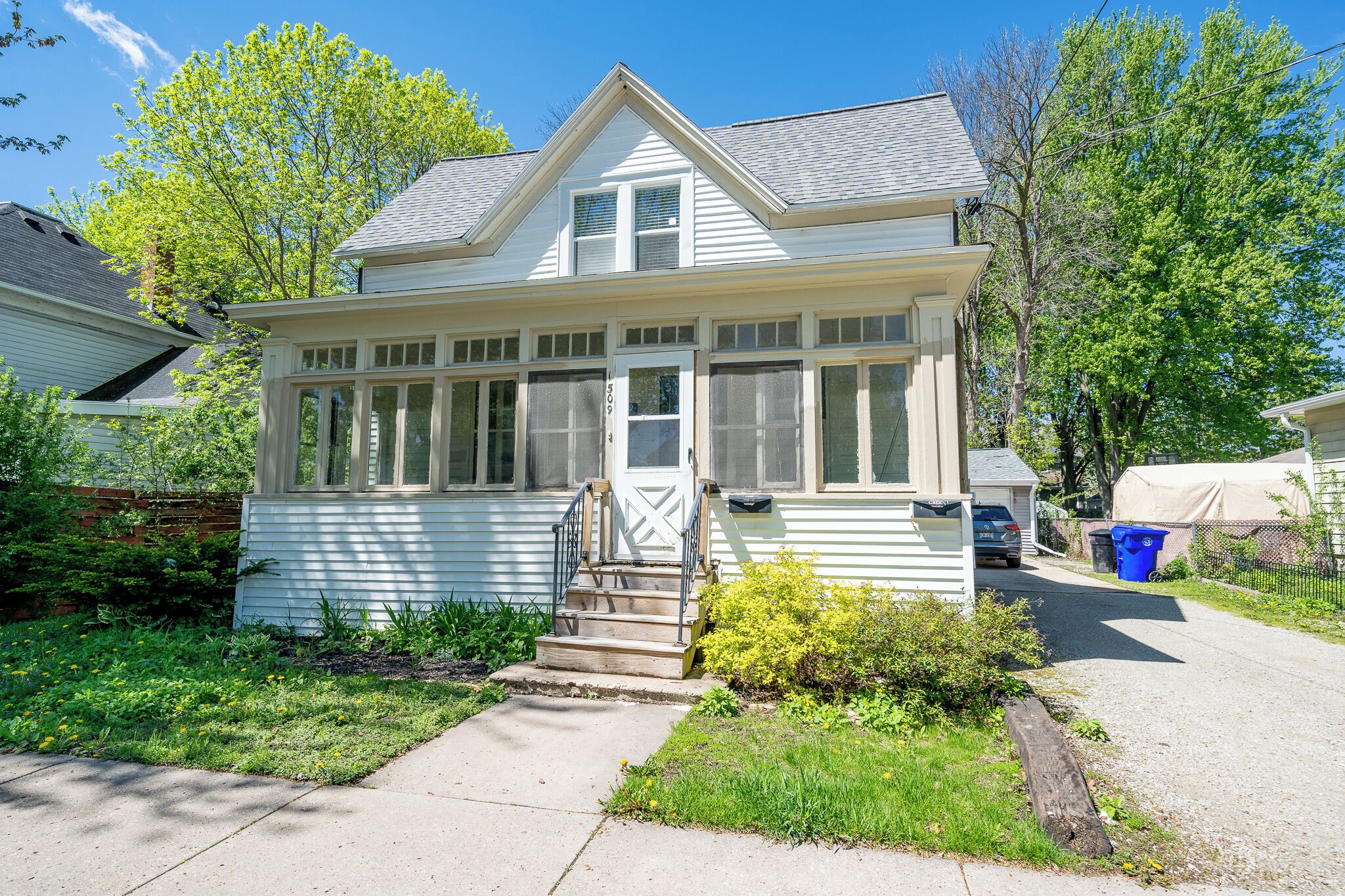- Charming home exterior with classic white siding and front porch steps   - Surrounded by greenery and peaceful neighborhood atmosphere   - Driveway parking and welcoming entry perfect for comfortable stays