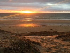 A beach with the sun setting over the ocean. - 4 Star Holiday Home in Skagen (Skagen)