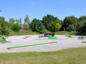An outdoor area with picnic tables and green play structures. - 4 Star Holiday Home in Skagen (Skagen)