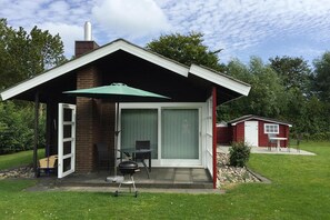 A single-story house with a covered patio, a sliding glass door, and a small attached garage. - Inviting log House With 2 Terraces and Cozy Fireplace in Damp (Damp)