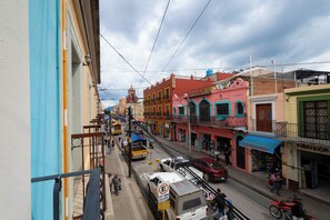A street view with colorful buildings, a visible hotel sign, and a tram. - HOTEL POSADA DON MATIAS (Oaxaca)
