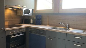 Una cocina moderna con electrodomésticos integrados, lavavajillas y un fregadero.