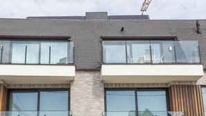 Un immeuble moderne à deux étages, doté de grandes fenêtres et de balcons.