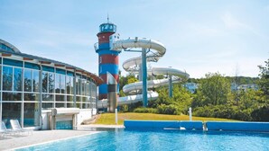 Una piscina con tobogán y una alta estructura tipo torre.